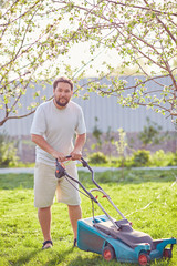 low angle view of young man mowing lawn