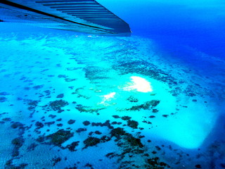 Aerial view of beach island in Great Barrier Reef from sky out of air plane