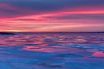 Naklejka na ściany i meble Sunset over a frozen lake