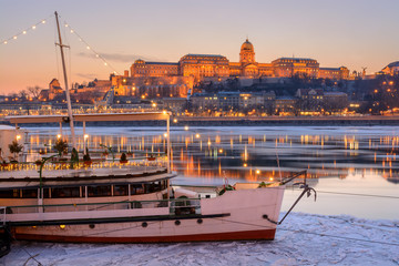 Illuminated boat against Royal palace in Budapest