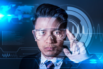 The abstract image of business man using a smart glasses or vr glasses overlay with virtual hologram image. the concept of communication, internet of things and future life.