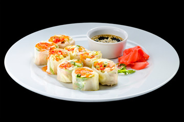 Fresh Vegetable Spring Rolls with soy sauce and ginger in a white plate, isolated on black background