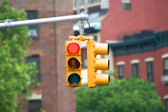 Red color traffic light with buildings in the background. Traffic light wallpaper.