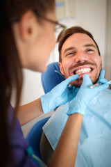 Orthodontist in dental clinic looking patient's bite