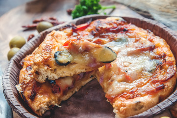 Round sausage pizza Margherita on a beautiful natural blackboard of olive . Selective focus. Close-up.
