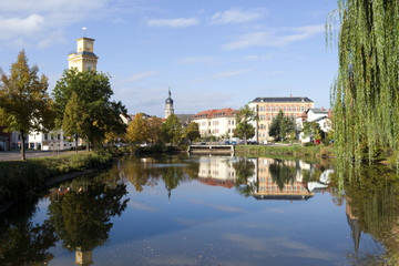 Fototapeta na wymiar Altenburg / Germany: Autumnal view over the „Little Pond“ to waterworks tower, St. Bartholomew steeple and Martin Luther School