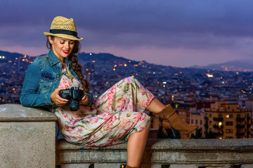 woman viewing photos while sitting on parapet in Barcelona