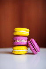 Vibrant colorful macarons on white wooden table. Text space