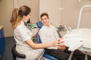 Fototapeta premium A woman doctor dentist in the office communicates with the patient. Stomatology. Medicine.