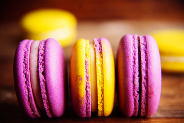 Colored macaroons pastel colors with different flavors on glass plate with paper towel. Bright and...