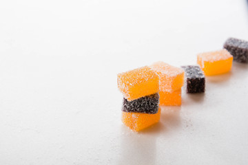 Assortment of colorful fruit jelly on white marble.