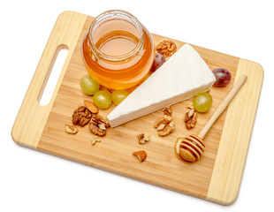 brie or camambert cheese and honey on a white background