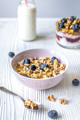 Homemade fitness granola with yoghurt and berries on white kitch