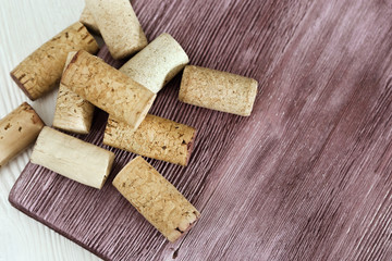Used corks from bottle with red wine on wooden surface. Old corks on natural wood desk red colored.  Copy space. View from above.
