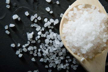  Wooden spoon with Italian seasoning-dried oregano with thyme, basil and vegetables.Oregano in a wooden spoon on a rocky concrete dark black background with a place for text.Top view.salt crystals pep