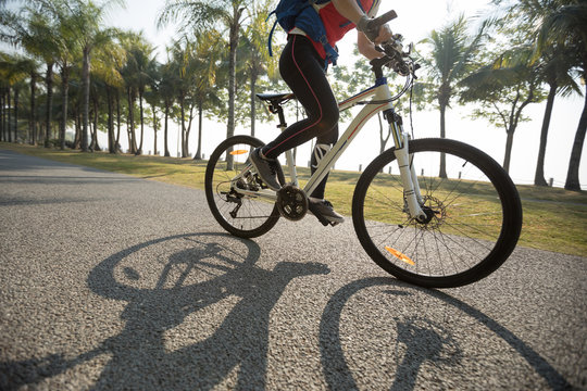 woman cyclist riding bike in a tropical park