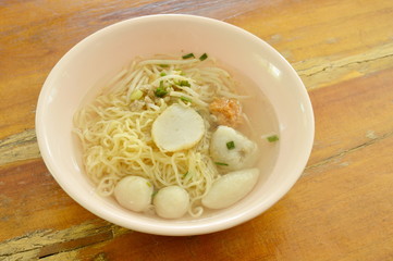 Chinese egg noodles topping fish dumpling and shrimp ball in clear soup on bowl © pedphoto36pm