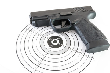Paper target and black gun on white