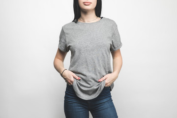 cropped shot of young woman in blank grey t-shirt on white