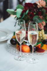 Glasses with champagne drink on a table. Happy newlyweds drinking. Loving couple created new family.