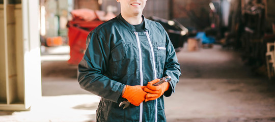 Smiling mechanic with keys in hands