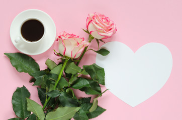 Obraz na płótnie Canvas Two pink blooming fresh rose flower with cup of coffee and paper heart for text on pink background