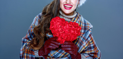 smiling elegant woman isolated on cold blue with red heart