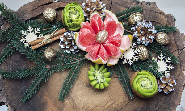 composition of fresh carved fruits decorated with fir branches