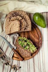 Avocado toast on gluten-free bread, rustic background. Guacamole with pumpkin seeds.Vegetarian food and Superfood diet concept.. Top view.