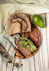 Avocado toast on gluten-free bread, rustic background. Guacamole with pumpkin seeds.Vegetarian food and Superfood diet concept.. Top view.