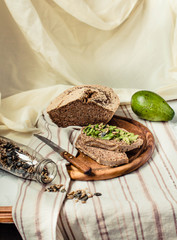 Avocado toast on gluten-free bread, rustic background. Guacamole with pumpkin seeds.Vegetarian food and Superfood diet concept.