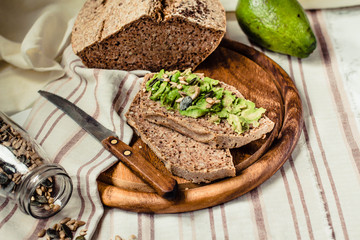 Avocado toast on gluten-free bread, rustic background. Guacamole with pumpkin seeds.Vegetarian food and Superfood diet concept.