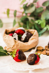 Homemade Chocolate Dipped Strawberries with coconut flakes and sugar in a paper bag. Ready to Eat. Healthy dessert and Valentine's Day concept.
