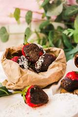 Chocolate covered strawberries with coconut flakes and sugar in a paper bag. Ready to Eat. Selective focus.