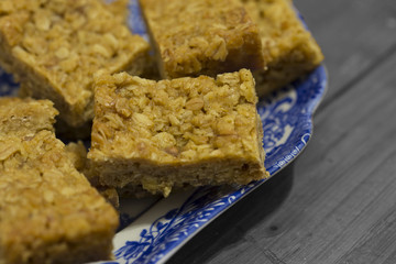 Caramel flapjacks on a dish with wood background