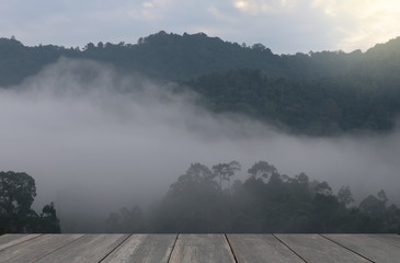 Landscape mountain view with mist in the nature background and wood floor 