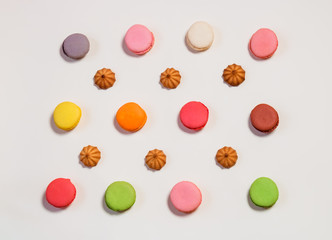 Colorful  pattern made of macaroon cookies and shortbread cookies on beige background