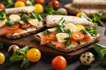 Smoked salmon sandwiches with tomatoes and eggs.