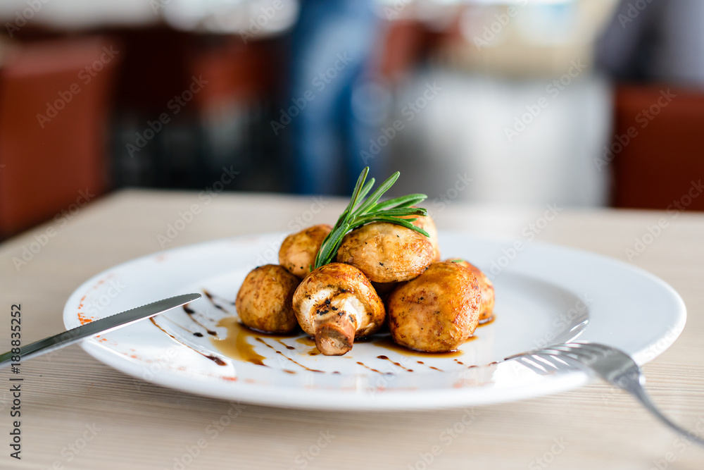 Canvas Prints delicious appetizing baked mushrooms with sauce in a white plate in a restaurant, shallow dof