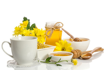 A cup of tea and bee products (honey, pollen) isolated on white background