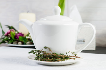 Fresh flavour warm herbal tea in a white teapot, selective focus