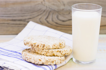 Healthy Rural Breakfast with wheat breadcrisps and a glass of cold milk. Napkin and rustic wood as...