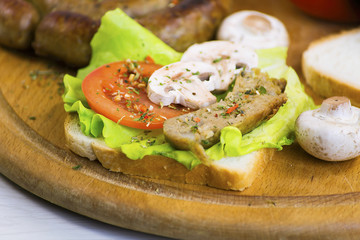 homemade sausage and sandwich with sausage, mushrooms and tomato