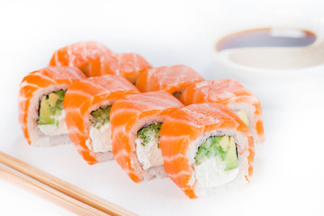 Delicious Philadelphia sushi rolls with rice, avocado, cream cheese and salmon on light background