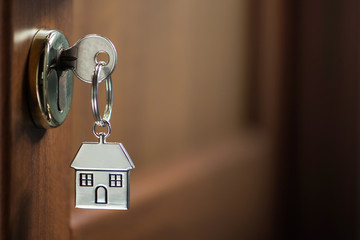 Silver house key in a door