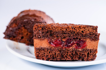 Delicious sweet chocolate piece of cake with cream in a white plate