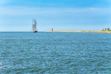 Żaglówka wchodząca do zatoki. Krajobraz z horyzontem, wodą i jachtem. © art08