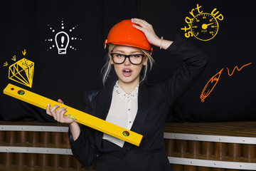 Beauty blonde businesswoman with designer or architect staff is standing against concrete wall with startup sketch on it