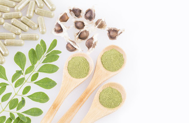 Fototapeta na wymiar Fresh leaves, powder, capsules and moringa seeds - Moringa oleifera