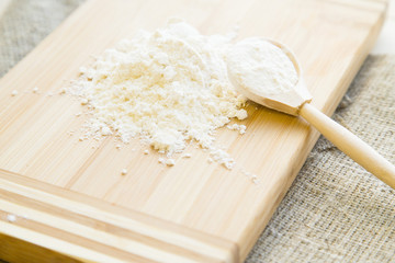 Kitchen, Baking, Pastry Concept. A wooden cutting board with a heap of flour and a wooden spoon on a linen cloth, close up